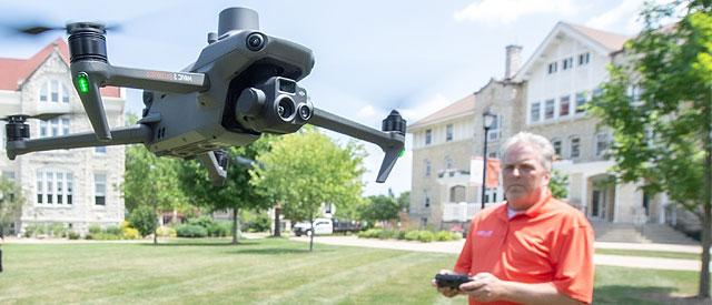 A professor flying and testing out a new drone outside at Carroll University.